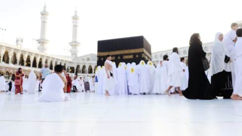 People in white garments gathered around the Kaaba in the Grand Mosque, Mecca.