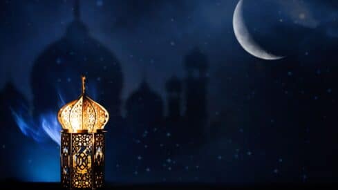 Ornate lantern with crescent moon and domes against a starry night sky.